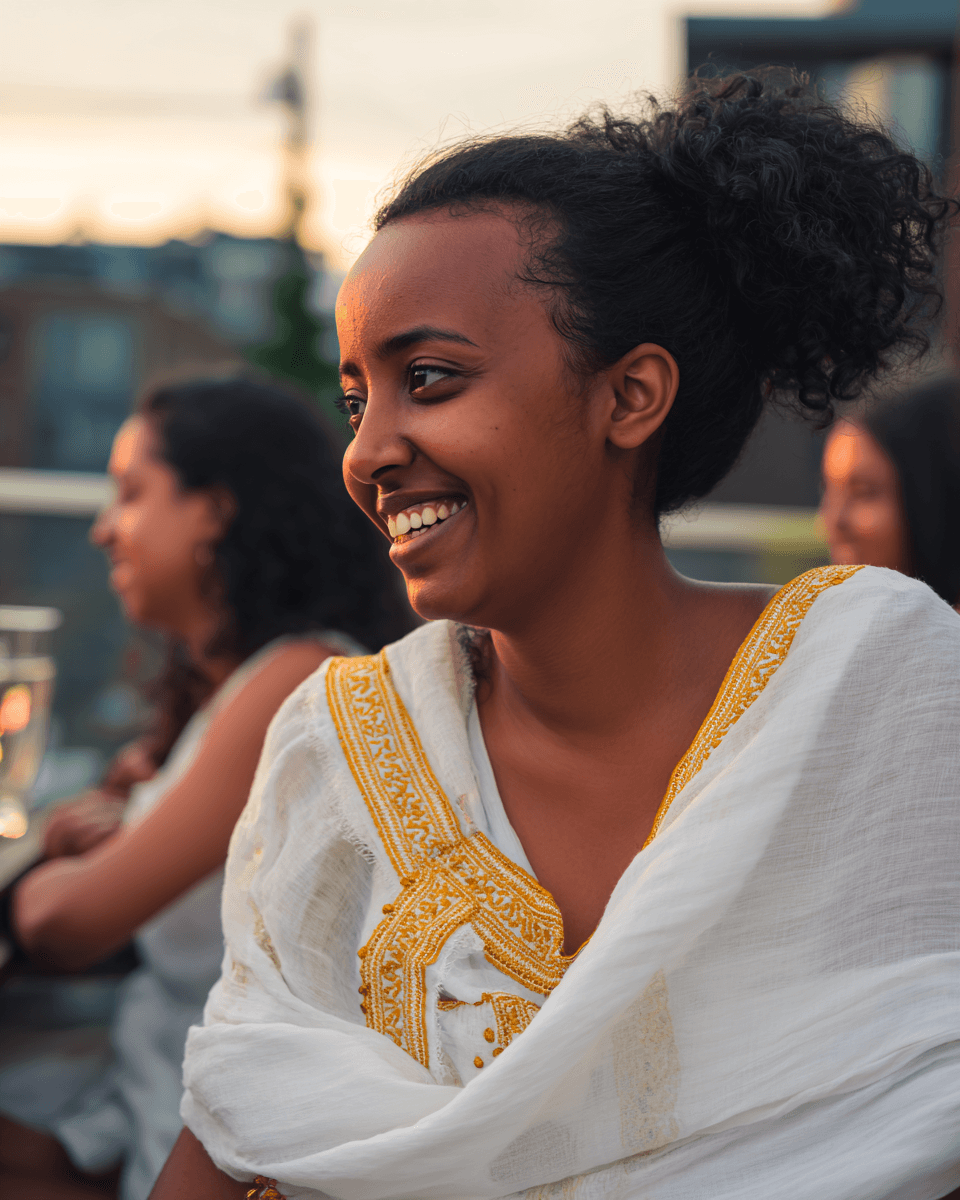 Ethiopian-Canadian woman in habesha kemis at rooftop gathering in Toronto