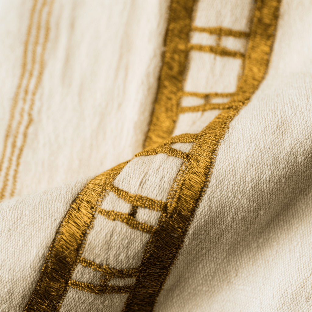 Close-up of hand-woven gold tibeb border on Ethiopian kemis